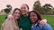 Multiracial portrait group of united female friends smiling at camera outdoors