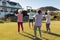 Multiracial seniors stretching hands while standing on grassy land in yard at nursing home