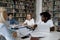 Multiracial students studying together sit at table in university library