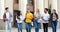 Multiracial students walking against university building during break