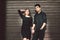 Multiracial stylish couple in black clothes posing on a background of a wooden wall. Turkish guy and caucasian girl date and love