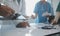 Multiracial team of doctors discussing a patient standing grouped in the foyer looking at a tablet computer, close up view