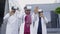 Multiracial team of three doctors wearing virtual reality glasses, working outside the hospital