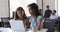 Multiracial women colleagues looking computer screen, discuss new software