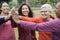 Multiracial women stacking hands outdoor at city park - Main focus on african woman`s hand