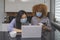 Multiracial workplace. Women collegues with medical mask working on the project with coffee