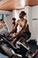 Multiracial young adults doing intense cardio workout on exercise bike at the gym