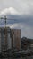 Multistorey building with construction crane jib against overcast sky