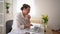 Multitasking businesswoman in a white shirt at her office. Video call with partners, she holds the microphone and speaks