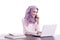 multitasking college student wearing hijab studying on her lapto