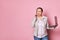 Multitasking working pregnant woman talking on mobile phone, negotiating with investors, holding laptop, pink background