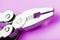 Multitool is a multi-functional tool on a pink background. The concept of an open, flying multi-tool with free space