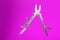 Multitool is a multi-functional tool on a pink background. The concept of an open, flying multi-tool with free space