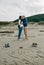 Mum, dad and baby written on the sand with the parents kissing behind