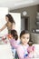 Mum and Daughters Washing Up In Kitchen