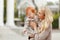 Mum gently embraces the redhead baby girl and laughing in autumn