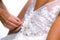 Mum`s hands closing the wedding dress of the bride