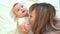 Mum and son lying on bed. baby learns to crawl.