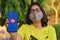 Mumbai, India, 2020. Girl wearing face mask showing Reliance Jio landing page on her mobile screen during Corona Virus Covid-19
