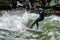 Munich, Germany - Jun 04, 2023: Surfer in the city river called Eisbach in the English Garden at Munich, Germany