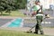 Municipal landscaper man worker cutting grass with string trimmer