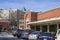 The Municipal Market in a tall red brick building with green trim and cars and trucks parked in the parking lot