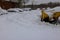 Municipal service removing snow on parking lot for car after snowfall