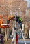 Municipal service workers in orange uniforms on a mobile aerial platform repair festive New Year\\\'s electric garlands