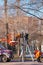 Municipal service workers in orange uniforms on a mobile aerial platform repair festive New Year\'s electric garlands