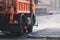 Municipal watering truck machines washes asphalt, process of street disinfection and cleaning from dust and dirt, cleaning flusher