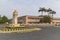 A Mural covered Municipal building beside a roundabout with a very Soviet style monument in Sao Tome.