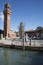 Murano, Italy, glass bottle Christmas tree in plaza in front of bell brick tower with clock