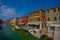 MURANO, ITALY - JUNE 16, 2015: Murano street with traditional houses and shops in front of nice water canals