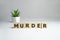 Murder Word Written In Wooden Cube. crime concept