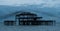 Murmuration of starlings over the remains of West Pier, Brighton UK. Photographed at dusk.