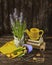 Muscari flowers in a pot, yellow tulips, scissors, seeds and a yellow watering can on a dark wooden background.