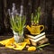 Muscari flowers in a pot, yellow tulips, seeds and a yellow watering can on a dark wooden background.