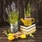 Muscari flowers in a pot, yellow tulips, seeds and a yellow watering can on a dark wooden background.