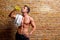 Muscle shaped man at gym relaxed drinking