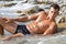 Muscle wet naked man lying in sea water
