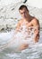 Muscle wet naked man sits in water