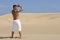 Muscled man in the desert dunes with white trouser