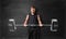 Muscled young man lifting hand drawn weight on the background of blackboard