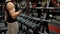 Muscleman lifting heavy dumbbells in gym, sport equipment, power bodybuilding