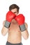 Muscly man wearing red boxing gloves in guard position