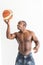 Muscular afro american athlete with basketball ball on white background