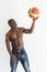 Muscular afro american athlete with basketball ball on white background