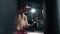 A muscular alone boxer is hits punching bag in the gym. Sportsman is boxing in dark hall. Self confident man is training
