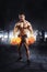 Muscular athlete bodybuilder lifting weight with flaming biceps