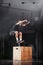 Muscular athlete jumping on wooden box. Smoke background